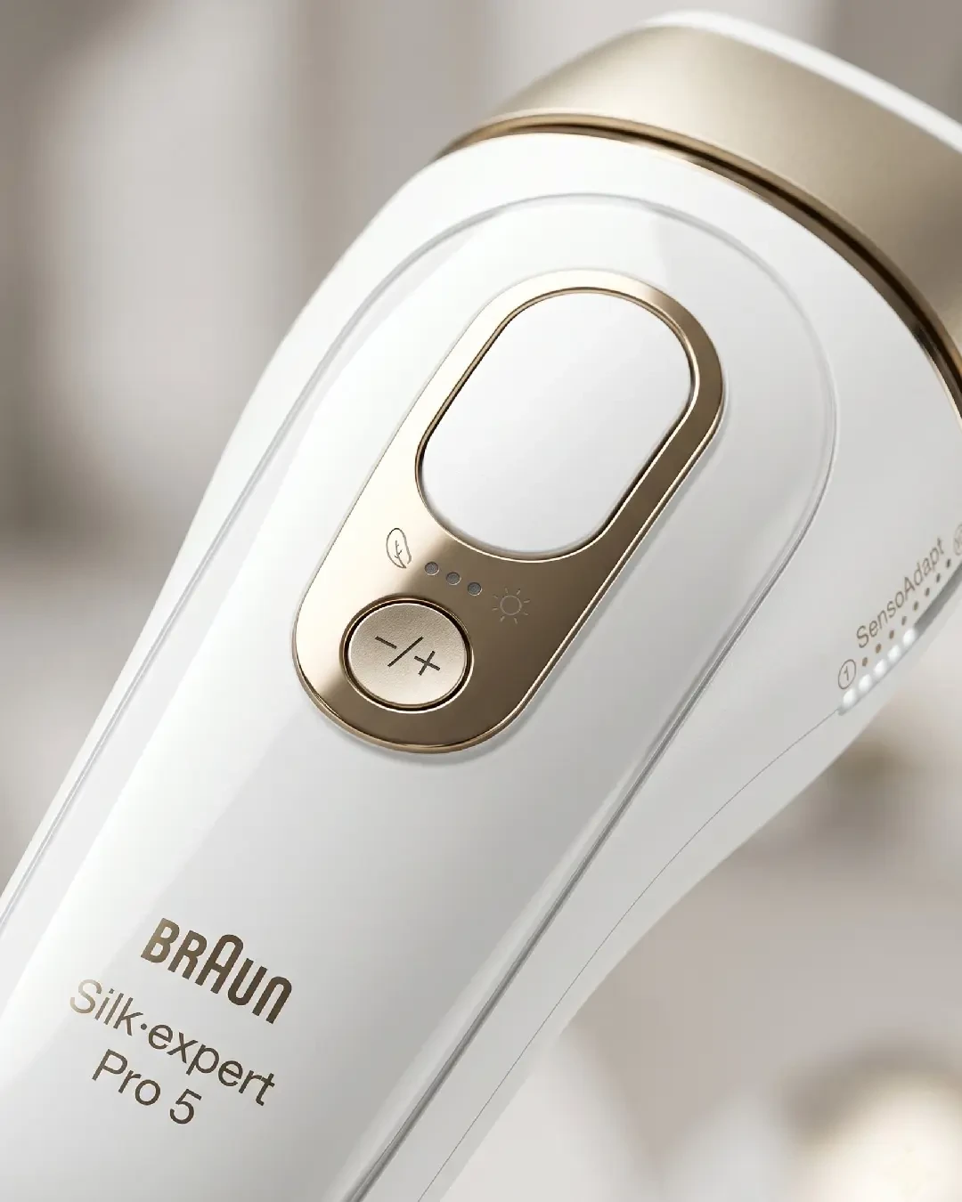 Bedienelemente des Braun Silk Expert Pro 5 in Nahaufnahme mit goldenem Auslöser und Intensitätsanzeige